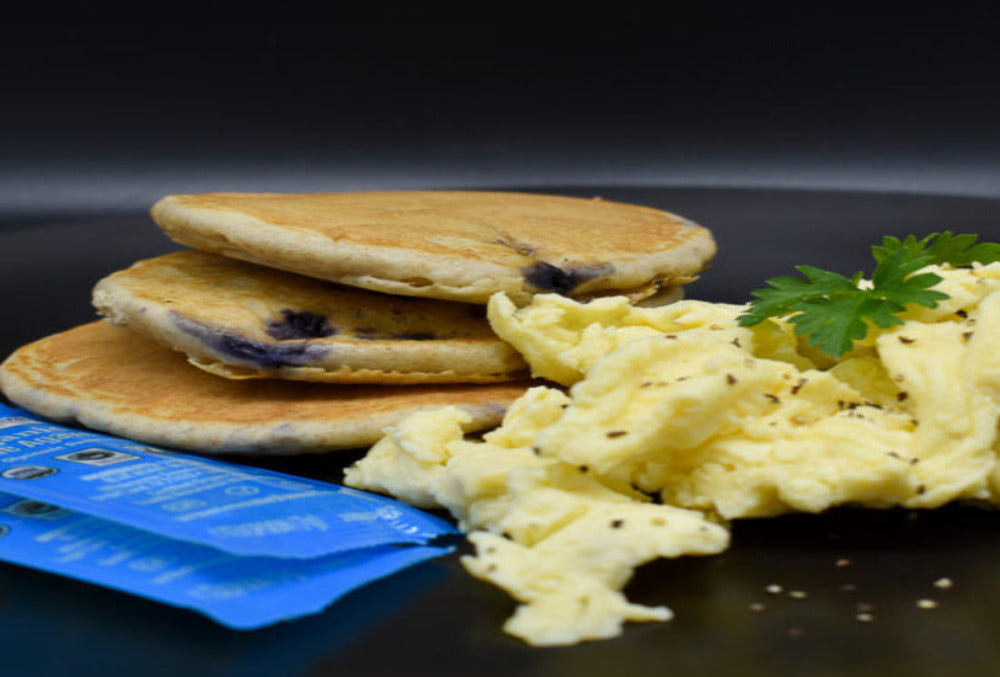 Wholesome fluffy blueberry pancakes with scrambled eggs.
